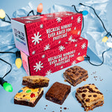 Red gift box with festive text and assorted brownies on a blue background with Christmas lights.